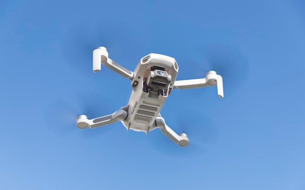 grijze drone quadcopter met digitale camera en sensoren die in de lucht vliegen