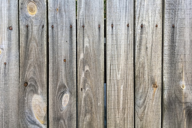 Grijze grenen plank houten hek verticale streep natuurlijke achtergrond. Houten textuur muur. Natuurlijke verlichting. Detailopname. Buitenshuis.