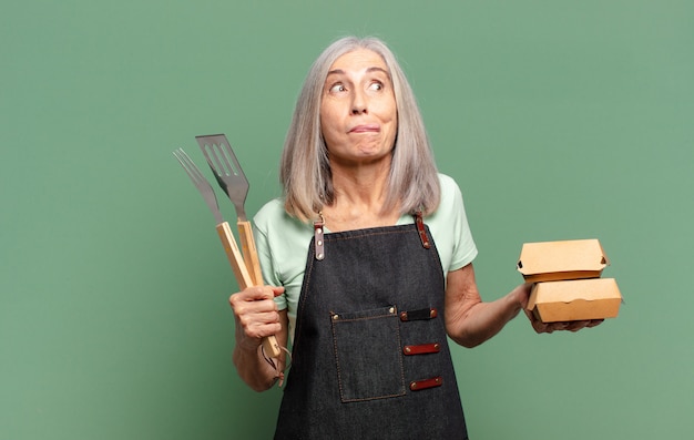 Grijze haar mooie barbecue chef-kok vrouw