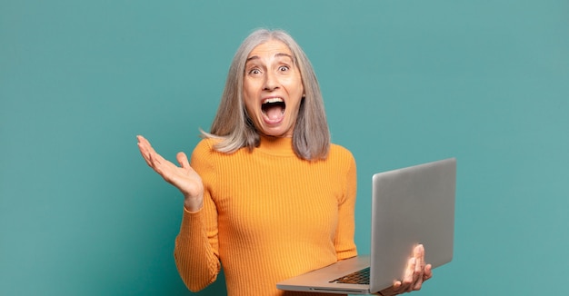 Grijze haar mooie vrouw met laptop.