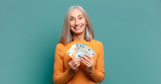 Grijze haren mooie vrouw met bankbiljetten