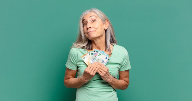 Grijze haren mooie vrouw met bankbiljetten