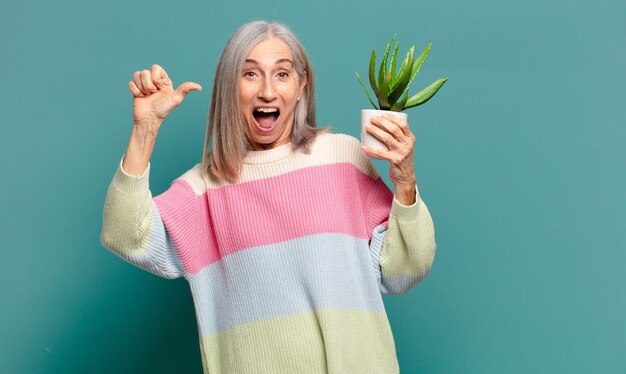 Grijze haren mooie vrouw met een cactus