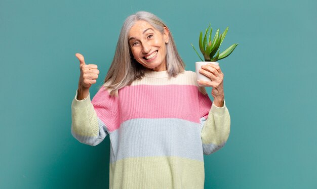 Grijze haren mooie vrouw met een cactus