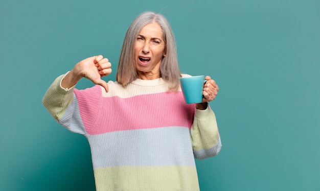 Grijze haren mooie vrouw met een kopje koffie of een thee