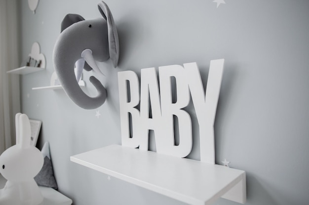 Grijze inscriptie baby op de muur in de kamer