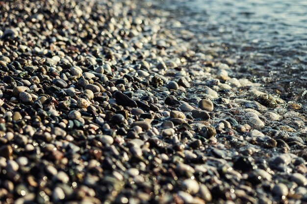 Grijze kiezelstenen strand textuur op zee als achtergrond