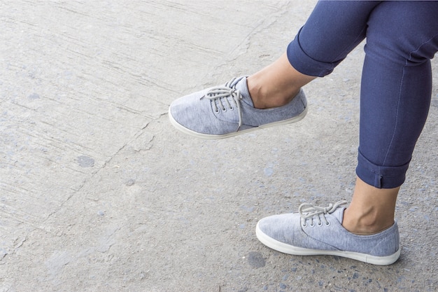 Foto grijze sneakers op aziatische vrouwelijke voeten