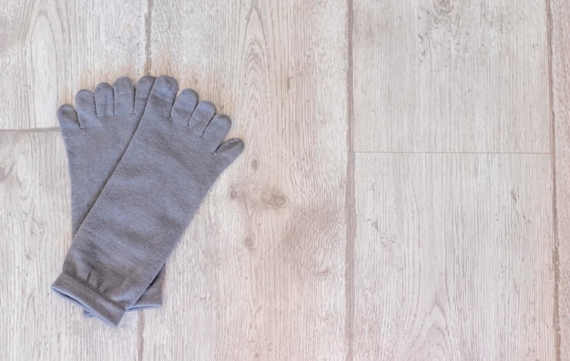 Grijze sokken met vingers op een houten vloer Geschikt voor yoga