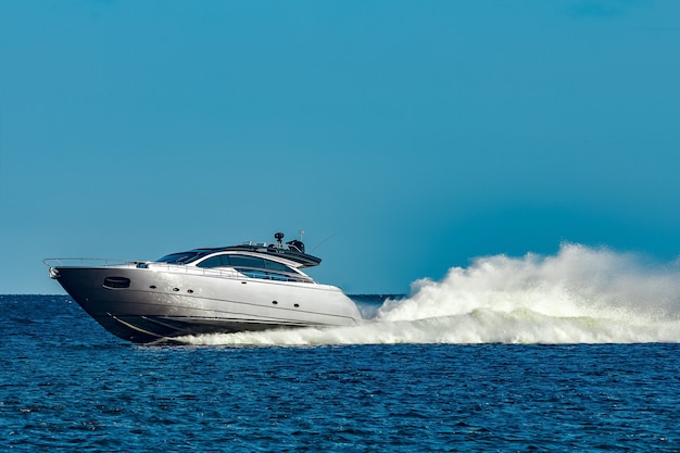 Grijze speedboot die snel door de rivier in Letland beweegt. Watersport