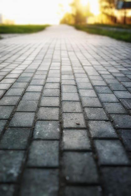 Grijze straatstenen pad verdrijft het vooruitzicht in de zonsondergang