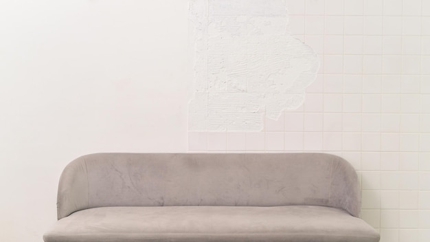 Grijze zachte comfortabele gezellige minimalistische bank stijlvolle indoor interieur meubels kamer bank decor ontwerp van witte bakstenen huis muur achtergrond moderne lege ruimte achtergrond in woonappartement huisstijl