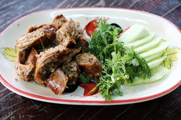 grill northern thai sausage with herbal vegetables on white dish