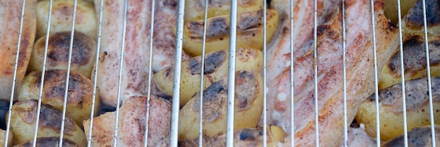 Grill potatoes and meat on wire rack closeup