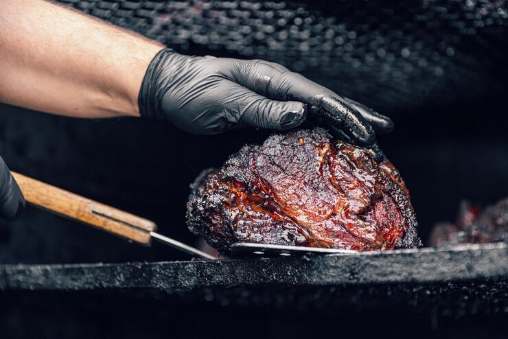 Grill restaurant kitchen Chef cooking beef meat in BBQ smoker