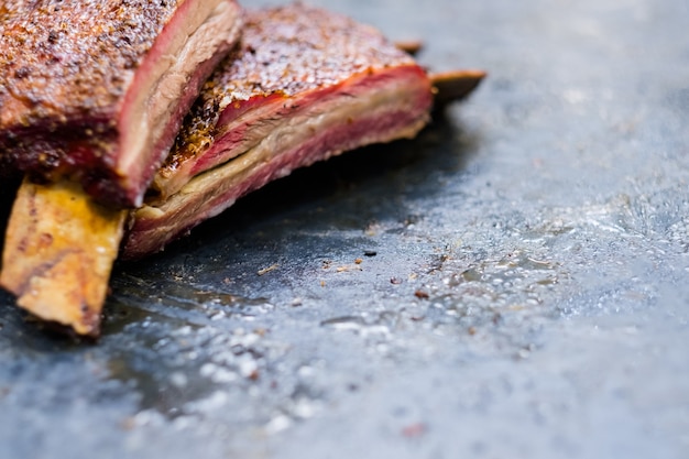 Grill restaurant. Meat recipe. Cropped closeup of BBQ smoked beef ribs. 