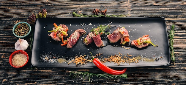 Grill Steak met komkommer, paprika en knoflook Koude snacks Bovenaanzicht Op een zwarte houten ondergrond Kopieer de ruimte
