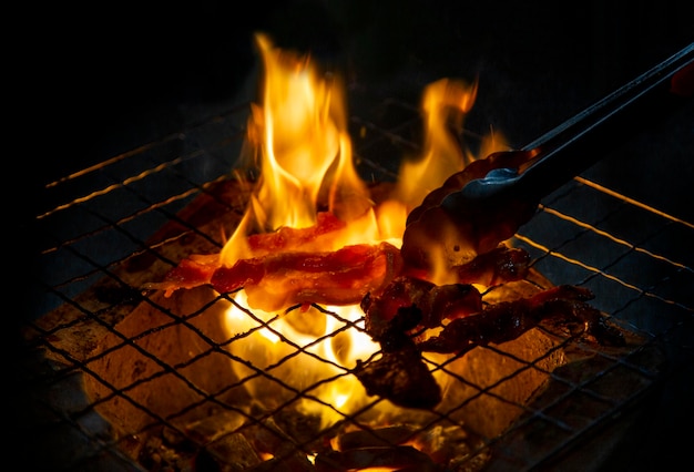 Grill varkensvlees op vuurvlam buiten met hete kolen