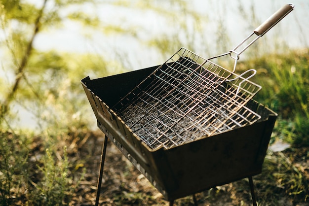 Grill voor frituren staat op de rand van een klif op een zonnige dag. koken voor het vuur. veilig vuur op de natuur in de barbecue. alles voor een picknick.