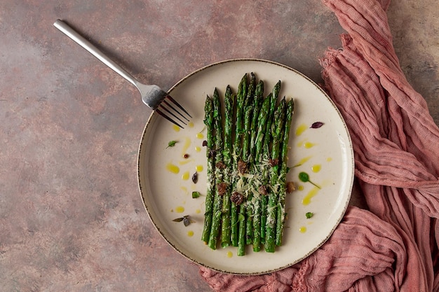 Grilled asparagus spices and herbs parmesan cheese on a beige plate top view rustic no people