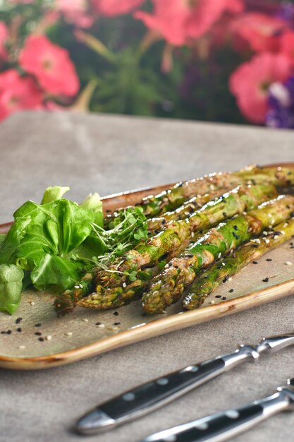 Grilled asparagus with peanut sauce on a plate selective focus