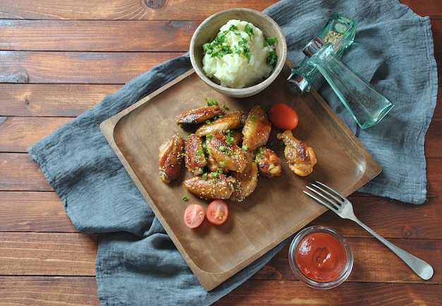 Grilled, barbecue chicken wings, tasty food for dinner or lunch. Fried chicken wings with sesame seeds. Fast food concept