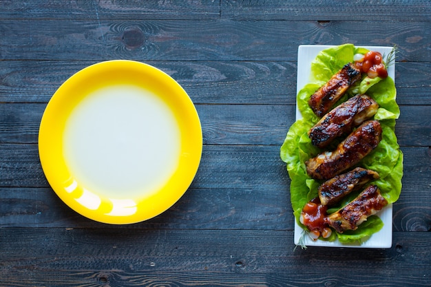 Costine di maiale alla griglia barbecue con verdure su legno