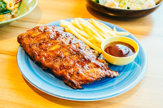 Photo grilled bbq or barbecue rib with french fries