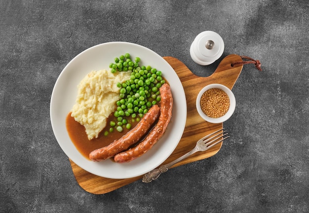 Grilled Beef bratwurst with mash potato and green pea. German sausages. Rinderbratwurst.