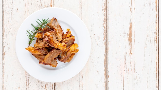 흰색 나무 질감 배경의 흰색 접시에 오레가노와 로즈마리를 곁들인 구운 쇠고기 등심 스테이크 고기와 텍스트 상단 테이블 보기를 위한 복사 공간