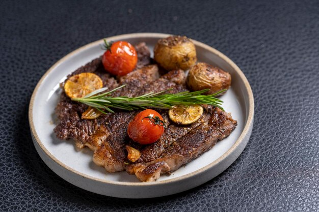 Grilled beef meat with grilled tomato and onions perspective view.