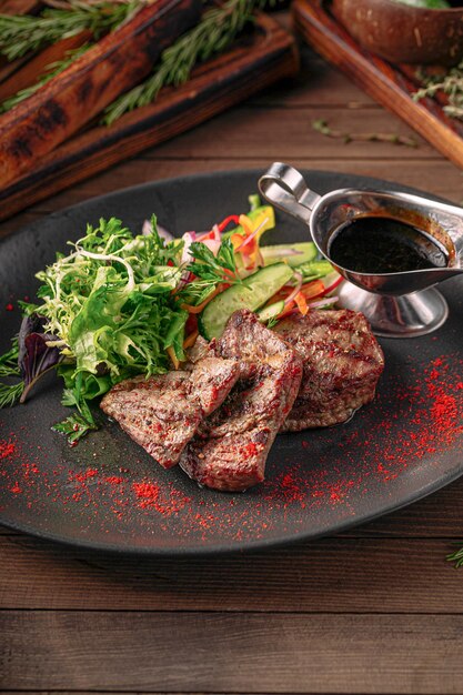 Grilled beef meat with salad and sauce