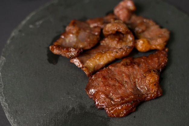 黒の背景スタジオの上のプレート上のグリル牛肉