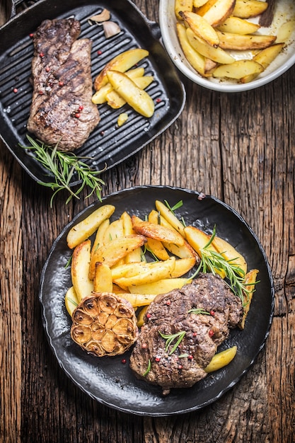 Grilled beef Rib Eye steak with garlic american potatoes rosemary salt and spices.