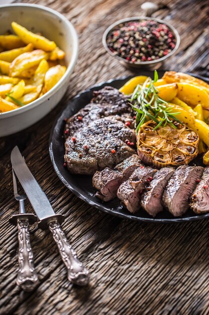 Grilled beef Rib Eye steak with garlic american potatoes rosemary salt and spices.