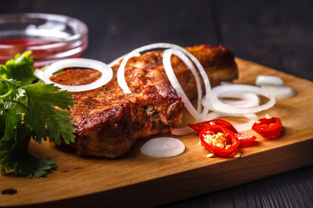 Grilled beef sliced on red plate over wood