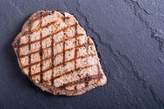 Grilled beef steak on cutting board Food background