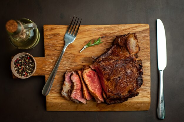 grilled beef steak on a cutting board on a stone background