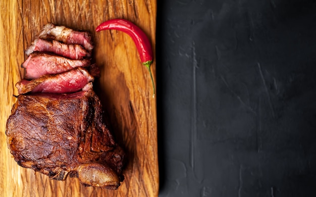 grilled beef steak on a cutting board on a stone background