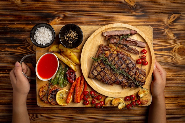 Grilled beef steak on the dark wooden surface.