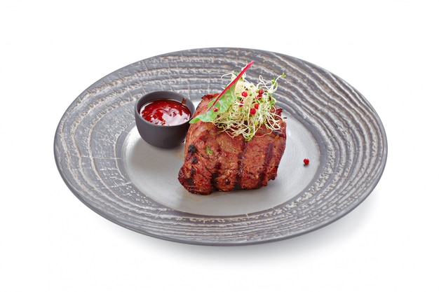 Grilled beef steak on grey plate isolated on white