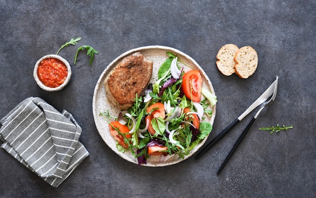 Bistecca di manzo alla griglia media con insalata mista e pomodori