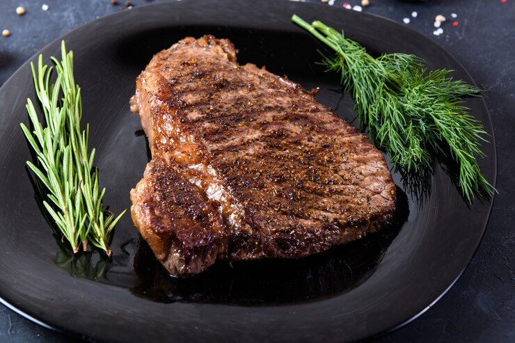グリルした牛肉ステーキリブアイ暗い表面では珍しい