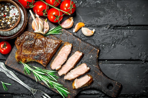 Grilled beef steak with rosemary and tomatoes