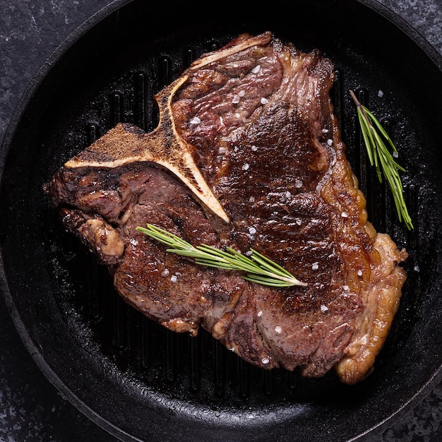 Grilled beef steak with spices in a frying pan