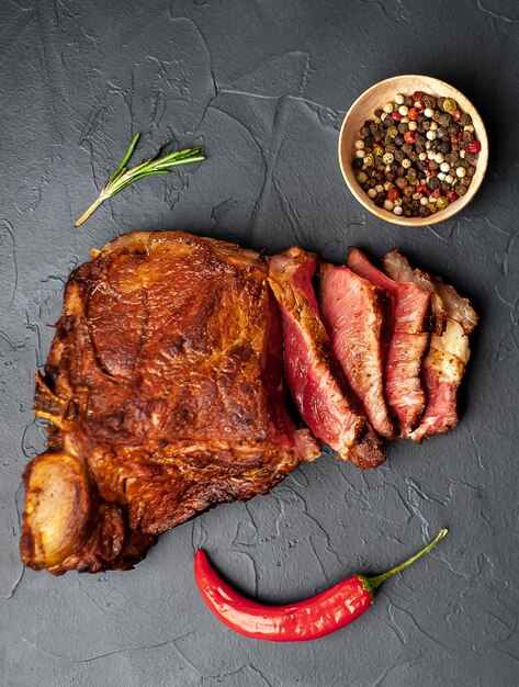 grilled beef steak with spices on a stone background
