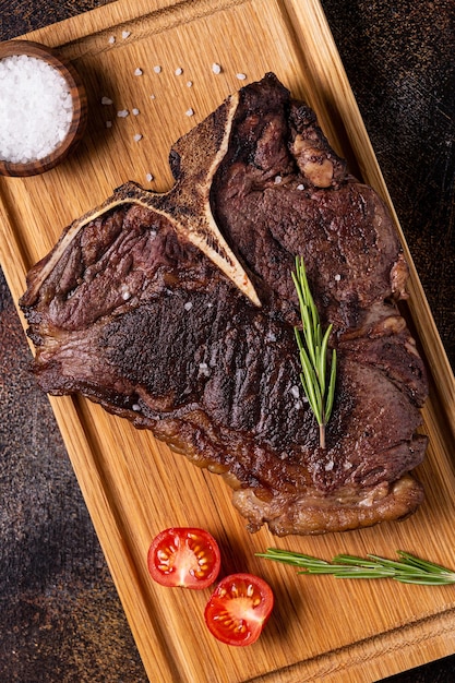 Grilled beef steak with spices on a wooden board