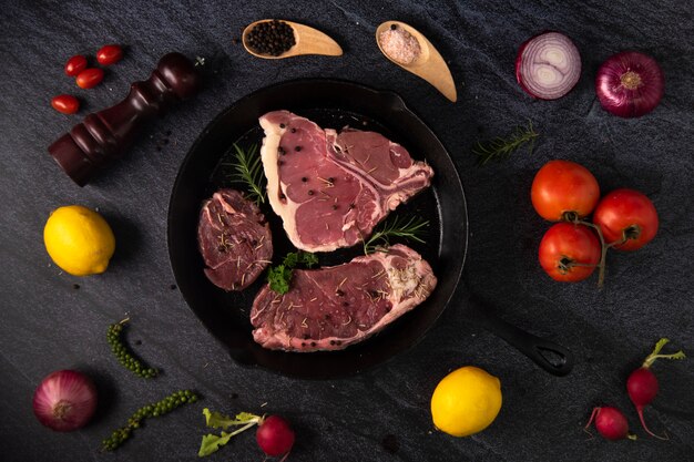 Grilled beef steaks with spices on black pan