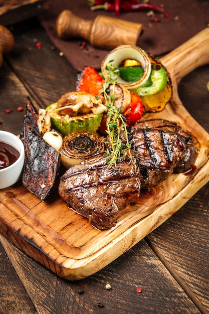 grilled beef steaks with vegetables and sauce