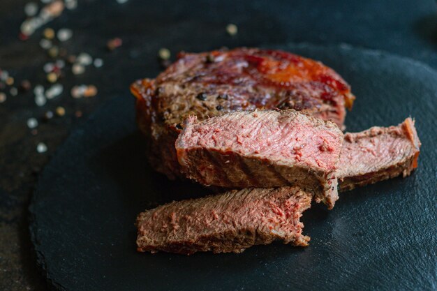 Grilled beefsteak ribeye on a dark plate